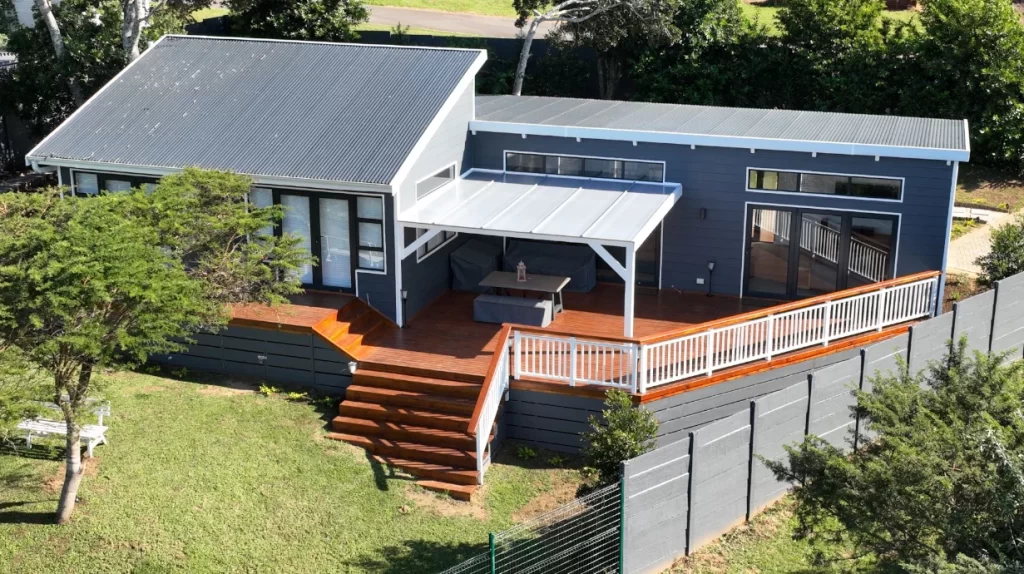 The new timber house has stacking doors along the length of the living room and kitchen which open out on to the sun deck